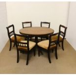 An oval breakfast table with marquetry detailing on tripod base with six chairs