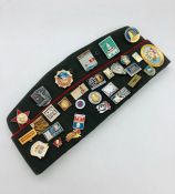 A Russian Military Cap with a wide selection of pins and badges.