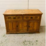 A pine sideboard with two drawers and cupboard under