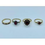 A selection of four 9ct gold rings all with rubies in a variety of settings.