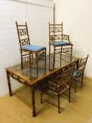 A dining table with six matching chairs (one base missing) bamboo and cane effect frame with cane