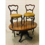 An oval tilt top breakfast table of Victorian origin with marquetry inlaid top with central pedestal