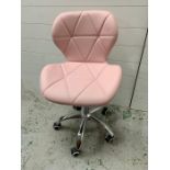 A pink faux leather swivel office style chair