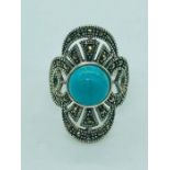 A silver ring set with marcasites and turquoise panel