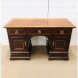 A mahogany kneehole desk, three drawers across top with recessed cupboards below