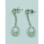 A pair of silver drop earrings set with CZ and opal