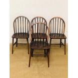 A set of four original dark wood Ercol Windsor dining chairs all with original labels