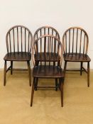 A set of four original dark wood Ercol Windsor dining chairs all with original labels