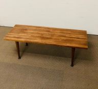 A mid century coffee table with tapered legs