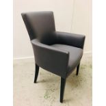 A grey upholstered occasional chair with arms