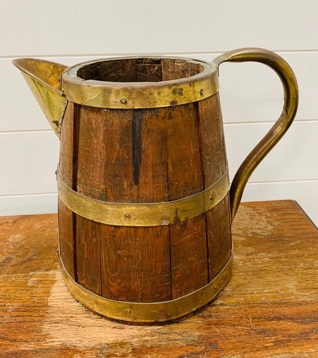 A large wooden barrel pitcher with brass hoops