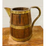A large wooden barrel pitcher with brass hoops