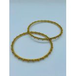 A pair of 22ct gold bangles in a twisted rope design. (32g)