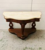 A marble topped console table with drawers, serpentine style front on three legs