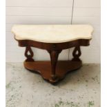 A marble topped console table with drawers, serpentine style front on three legs