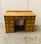 A pine double pedestal desk with nine drawers