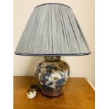 A blue and white floral theme china lamp with blue shade