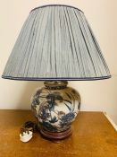 A blue and white floral theme china lamp with blue shade