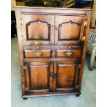 A Titchmarch and Goodwin oak drinks cupboard with a brush slide, brass hinges and handles