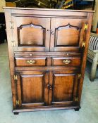 A Titchmarch and Goodwin oak drinks cupboard with a brush slide, brass hinges and handles