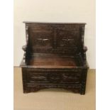 A carved oak monks bench with hinged seat