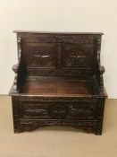 A carved oak monks bench with hinged seat