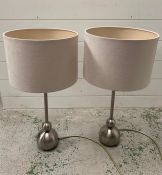 A pair of brush metal contemporary lights with white shades