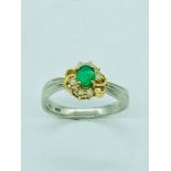 An 18ct white gold emerald and diamond ring