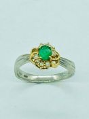 An 18ct white gold emerald and diamond ring