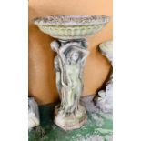 A garden statue of 'Three Graces style' bird bath.