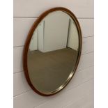 A rosewood oval mirror with metal band (20cm x 16cm)