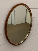 A rosewood oval mirror with metal band (20cm x 16cm)
