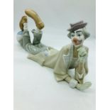 A Lladro figure of a clown lying down clown with his feet on a ball