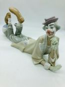 A Lladro figure of a clown lying down clown with his feet on a ball