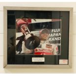 A Framed signed photograph of Lewis Hamilton with authentication stamp. Measures 39cms x 34cms.
