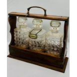 A Tantalus with three decanters and original key.