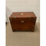 A campaign trunk on feet with protective brass straps and corners, brass name plate and Corry