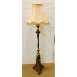 A floor standard lamp with rams head and fern detailing on three small feet and a tasselled cream