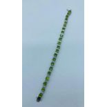 A silver CZ and Peridot line bracelet