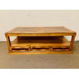 A solid coffee table with storage drawers and lower shelf