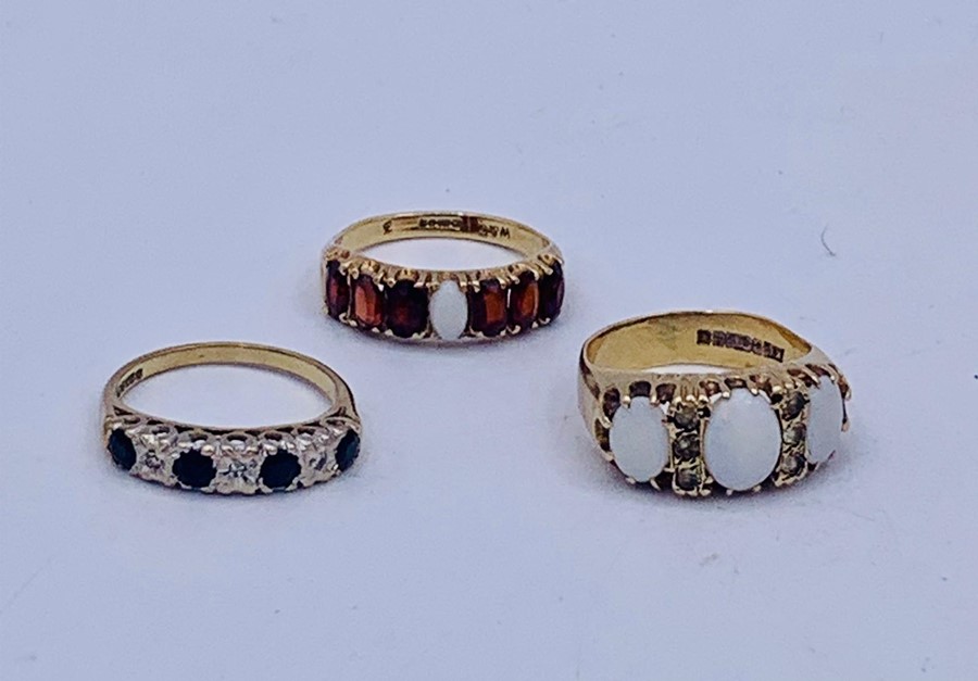 A selection of three 9ct gold rings with a variety of settings including Opal