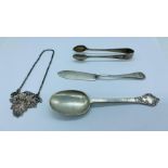 A selection of hallmarked silver items to include: a spoon, butter knife, sugar nips and a Port