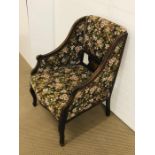 A floral embroidered upholstered armchair with decorative panel with marquetry