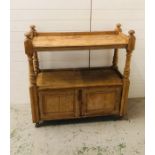 A pine sideboard with open shelf top and two small cupboards under on castors