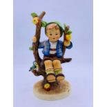 A Hummell figurine of a boy in a fruit tree
