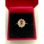 An 18ct yellow gold ruby and diamond flower head style ring