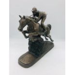 A signed Cold Cast Bronze on Resin of jumping horse with female jockey by Olive Tupton