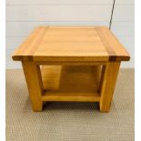 An oak square occasional table with shelf under