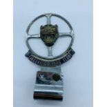 A Jaguar Drivers Club car badge.