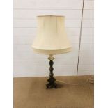 An ornate brass table lamp with oval cream shade